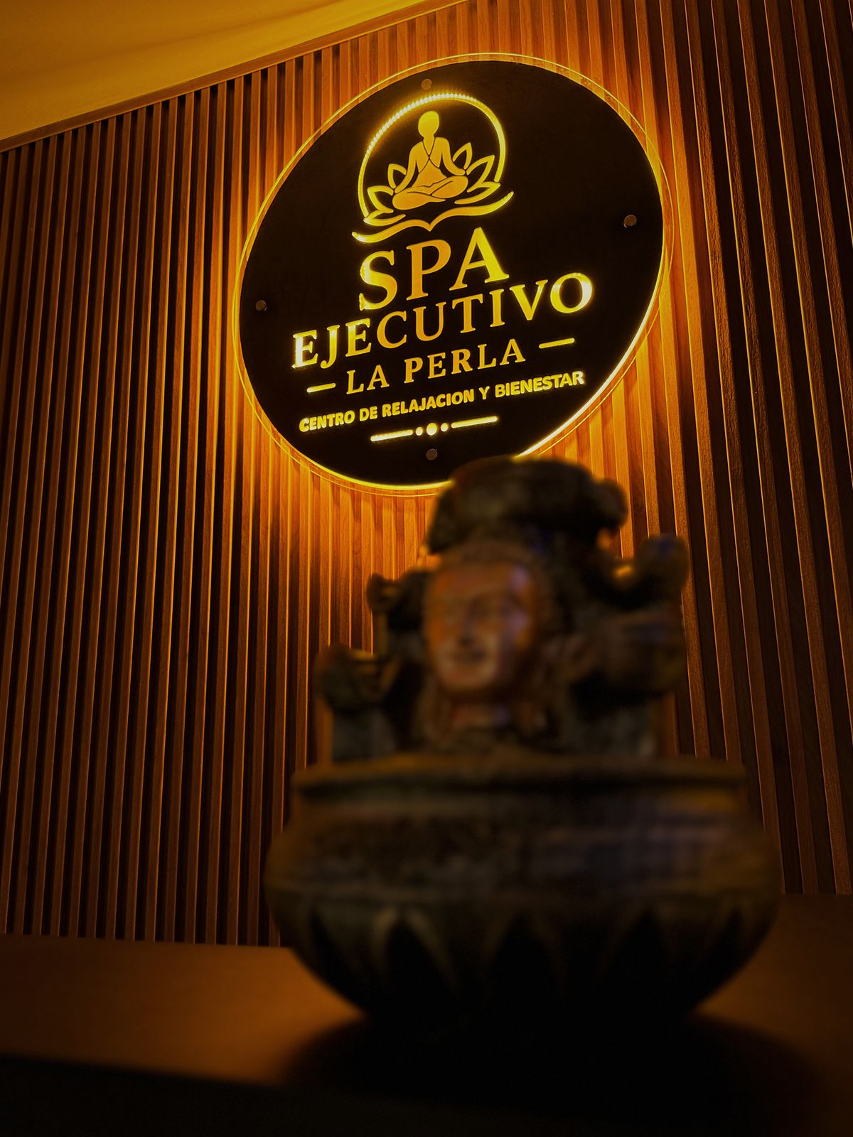 La recepción del SPA Ejecutivo La Perla con su logo iluminado